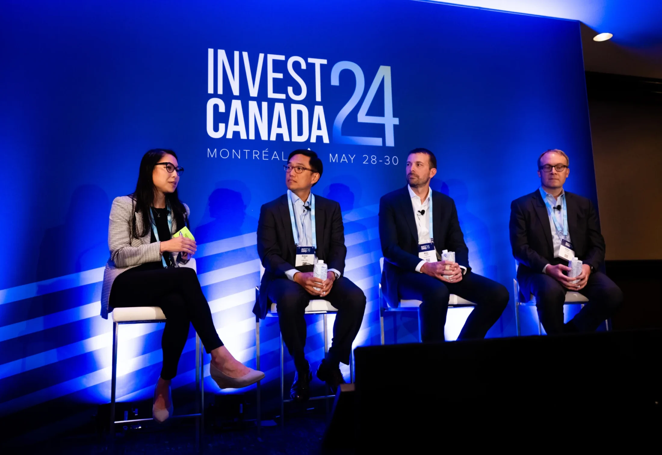 Panelists at Invest Canada 2024 event on blue background