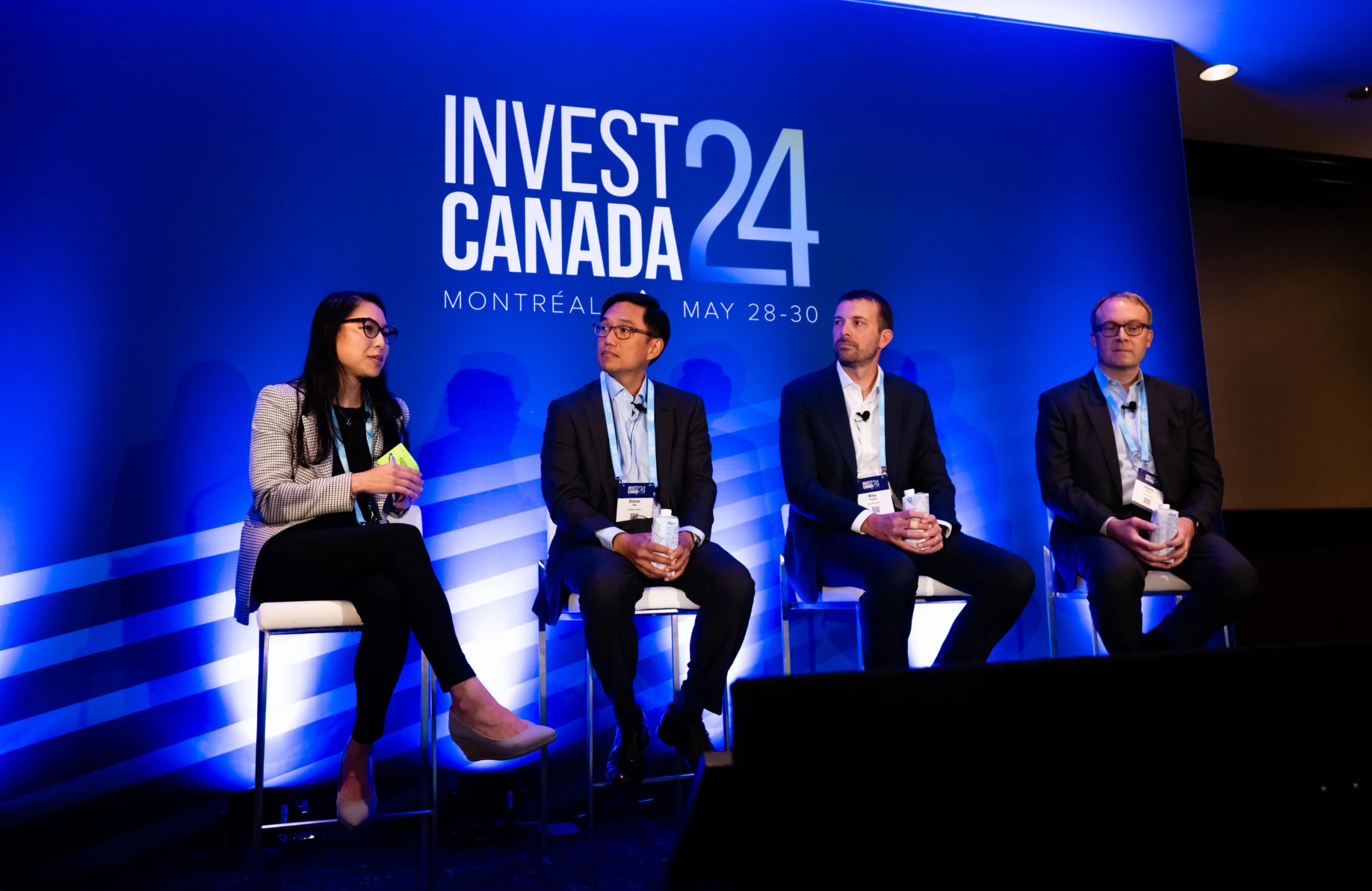 Panelists at Invest Canada 2024 event on blue background
